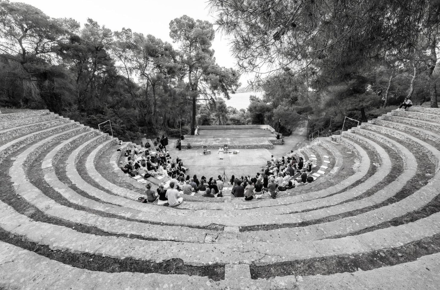 The open-air amphitheatre at dusk — the circle gathered