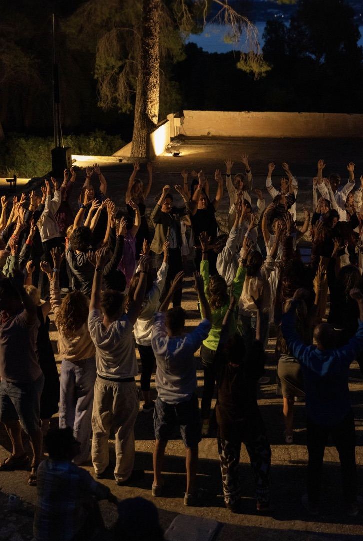 Hands raised under the night sky