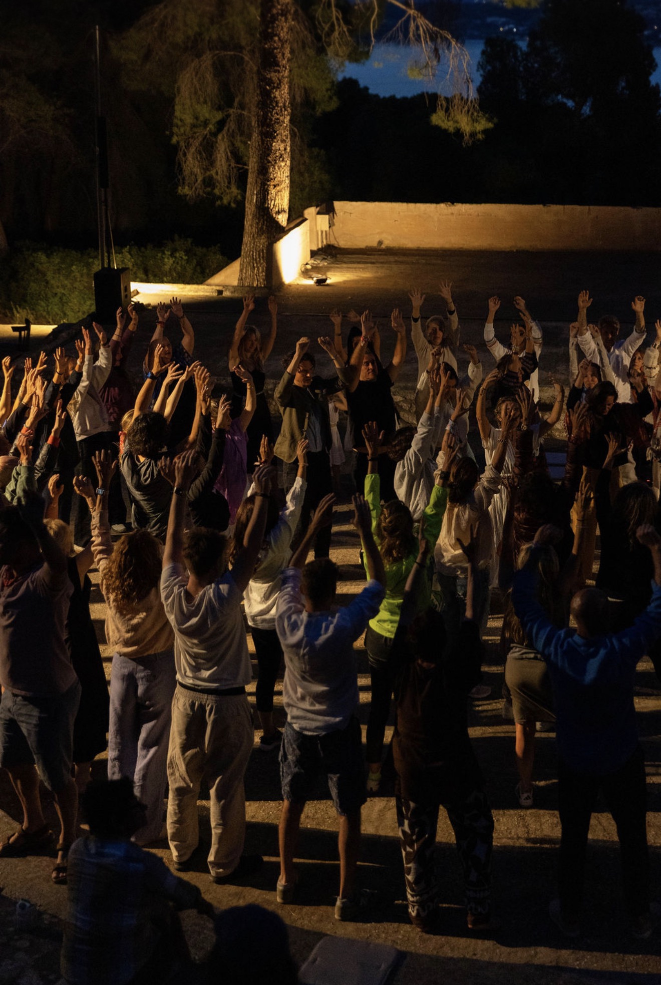 Hands raised together in the night amphitheatre