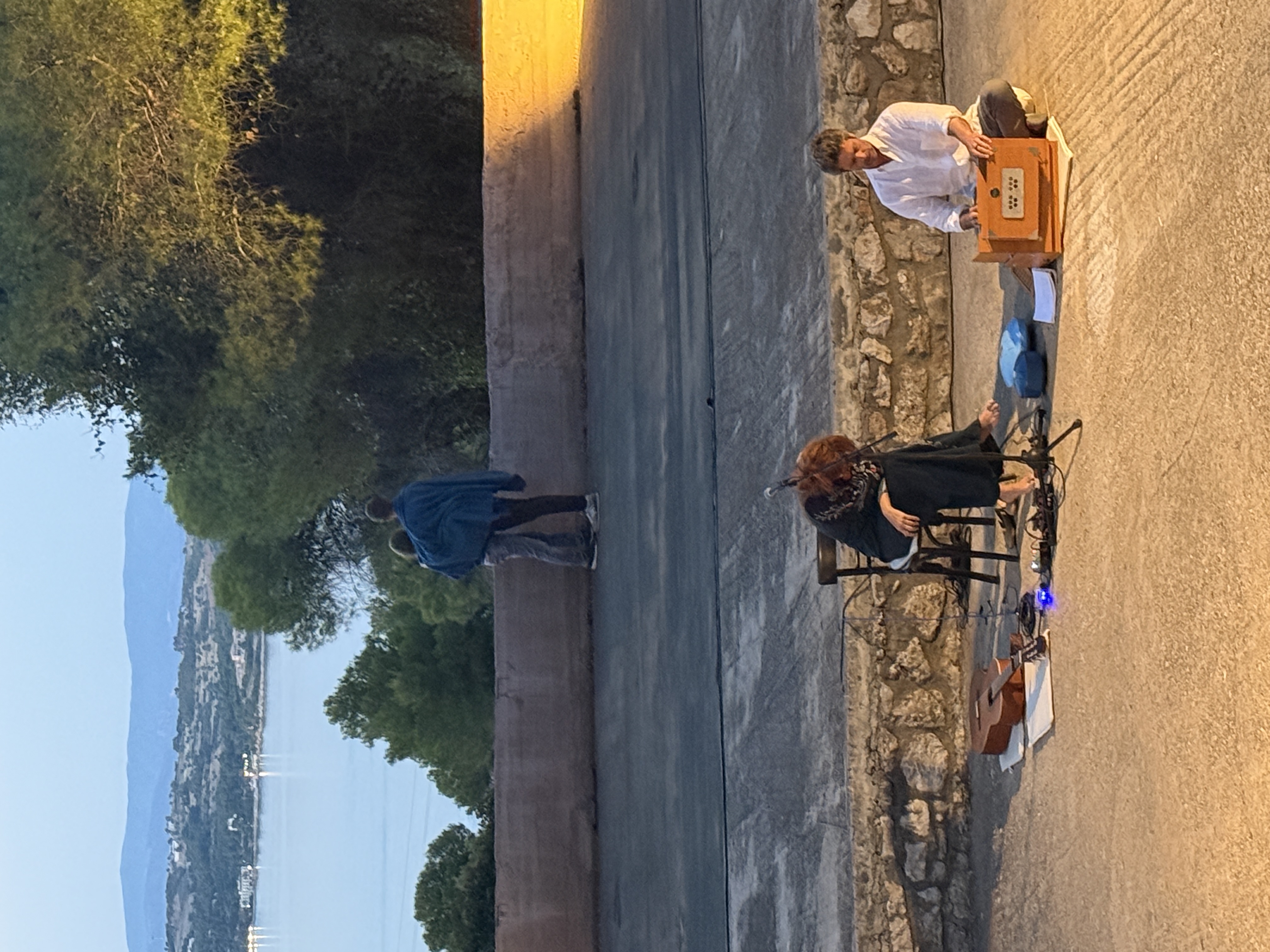Musicians performing at dusk overlooking the sea