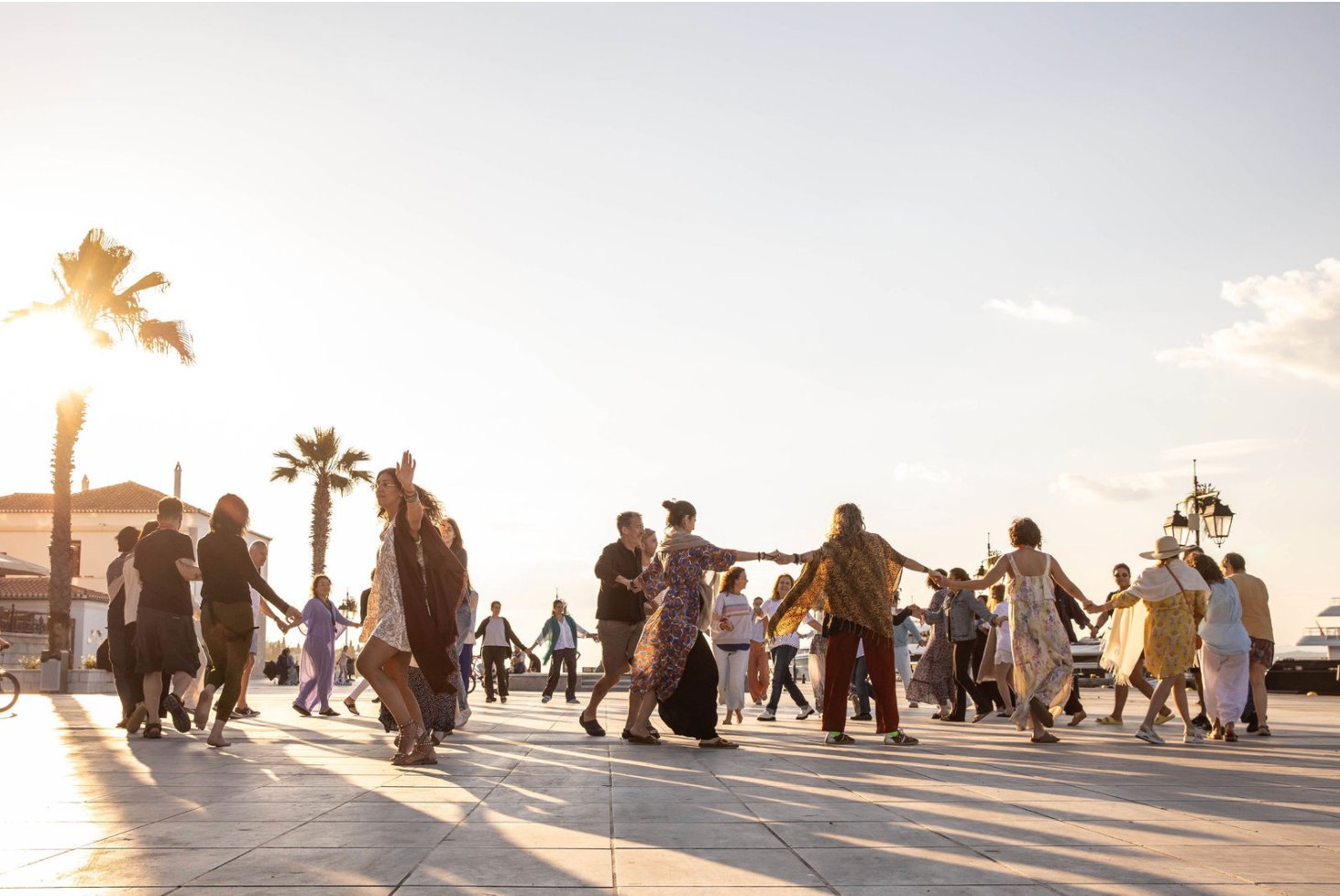The closing circle dancing by the sea at golden hour, Spetses